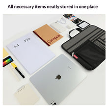 Collection of office supplies neatly stored in a black organizer on a white surface.
