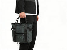 Person holding a green tote bag against a white background